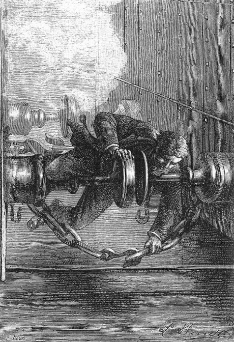 Suspendu d’une main entre le wagon de bagages…